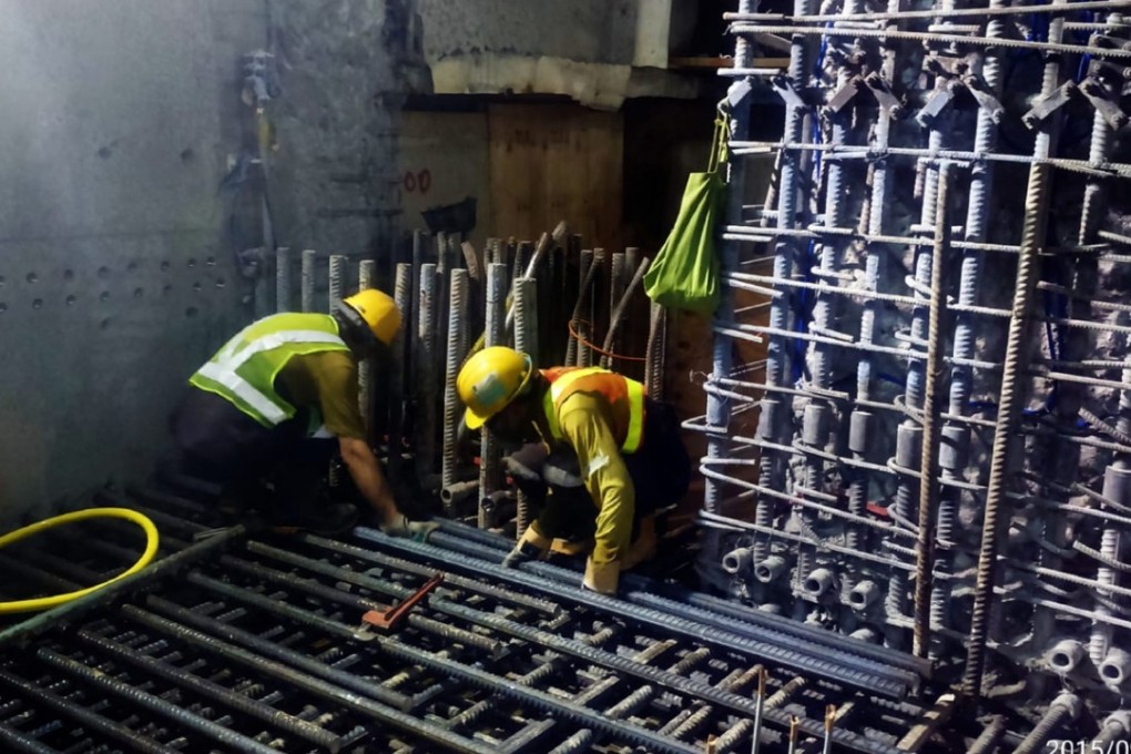 Workers in uniforms and safety helmets of Leighton Contractors (Asia), the main contractor in the Sha Tin-Central rail link, build the platform framework for Hung Hom station, in September 2015. Photo: SCMP