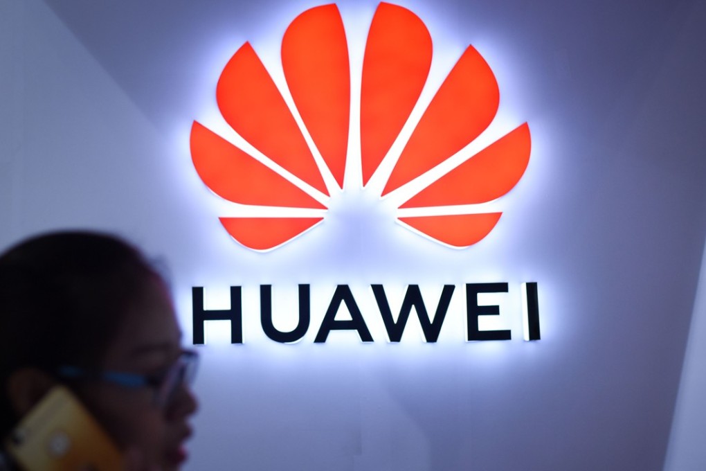 (FILES) This file picture taken on July 9, 2018 shows a woman using her mobile phone in front of a LED display board of Huawei at Beijing International Consumer Electronics Expo in Beijing. Despite being essentially barred from the critical US market, Huawei surpassed Apple to become the world's number two smartphone maker in the second quarter of this year and has market leader Samsung in its sights. Huawei has achieved this in part by refocusing away from the futile fight for US access and toward gobbling up market share in developing nations with its moderately priced but increasingly sophisticated phones, analysts said. / Agence France-Presse PHOTO / WANG Zhao / TO GO WITH China-telecommunication-Huawei-mobile-Samsung-Apple, FOCUS by Dan Martin