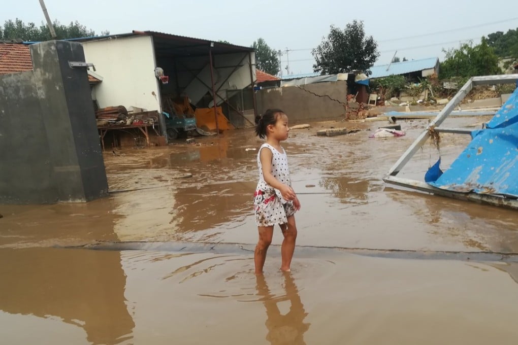 A girl wades through a flooded street in Shouguang on Tuesday after the city was battered by Typhoon Rumbia. Photo: Reuters