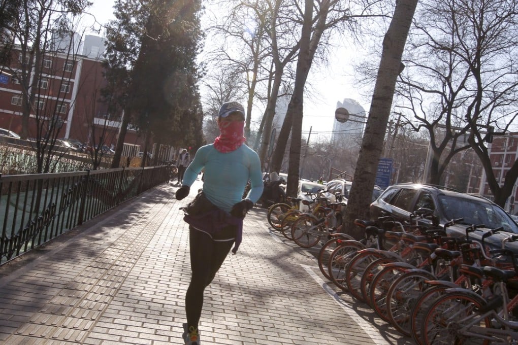 A woman jogs on the sidewalk in Beijing's central business district. The CEO of one Chinese tech start-up has not jogged for a while due to long working hours and worries over his company’s future. Photo: SCMP / Simon Song