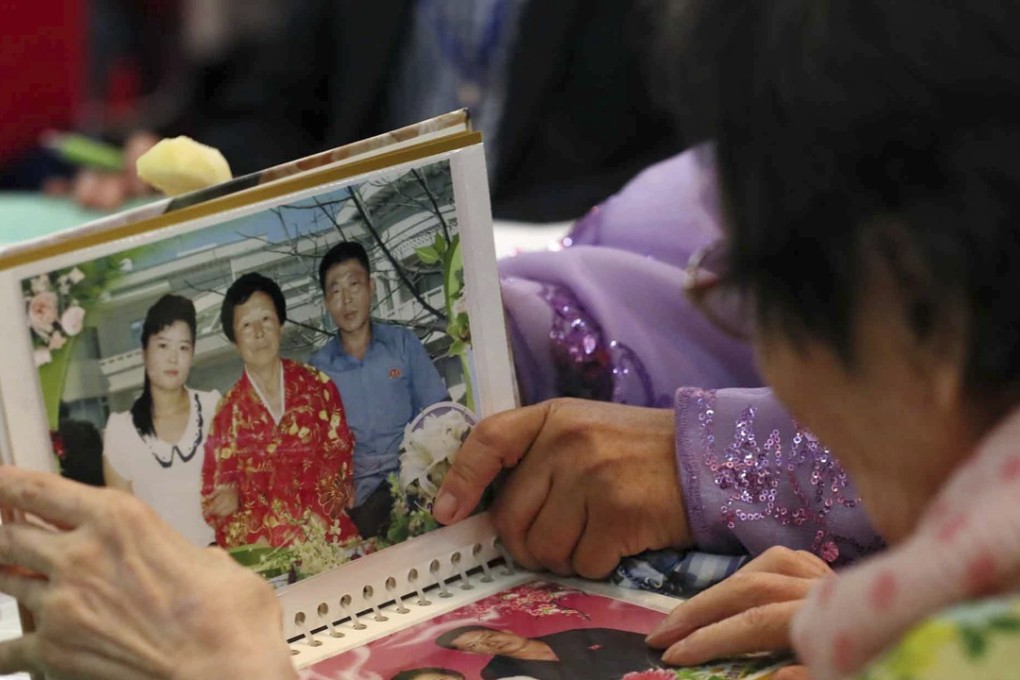 South Korean Han Shin-ja, 99, views photos of family members in North Korea during a reunion with her daughter on August 20. Photo: Yonhap