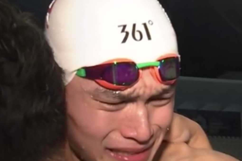 Sun Yang cries on the shoulder of a Chinese reporter. Photo: CCTV