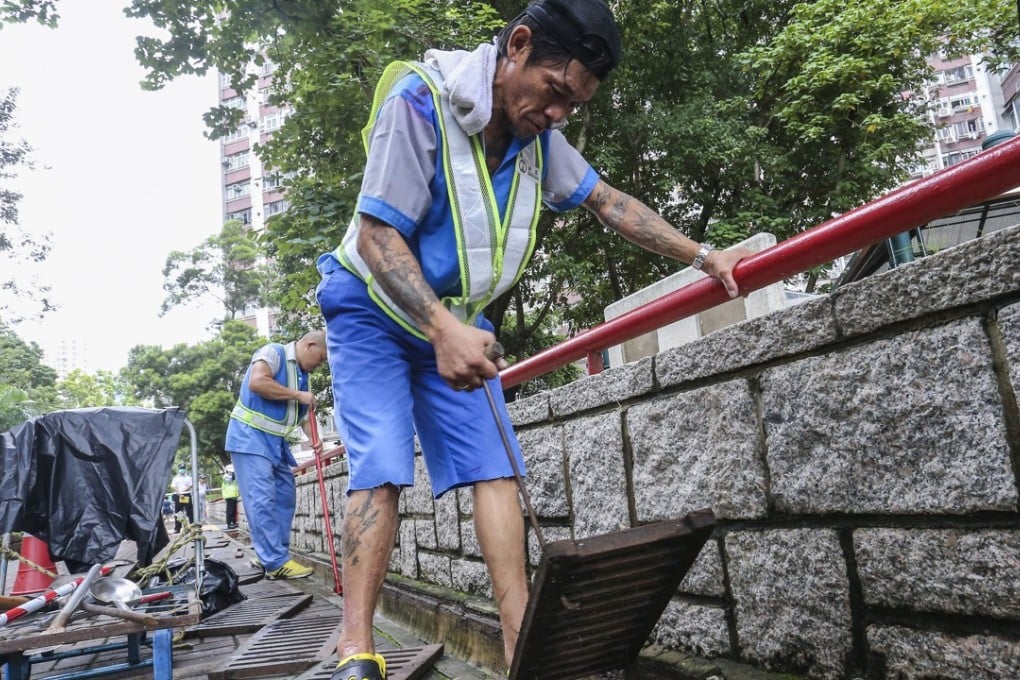 Workers from the Food and Environmental Hygiene Department clear drains to prevent mosquitoes breeding, in Wong Tai Sin on August 18. Photo: Dickson Lee