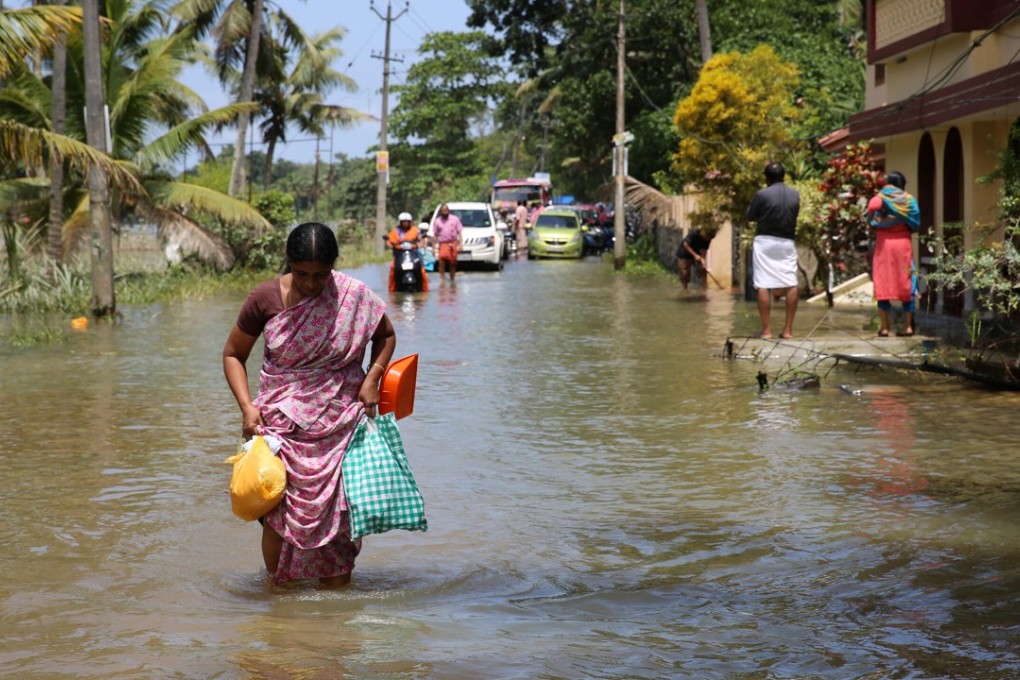 People wade through floodwater in India’s Kerala state. Photo: Xinhua