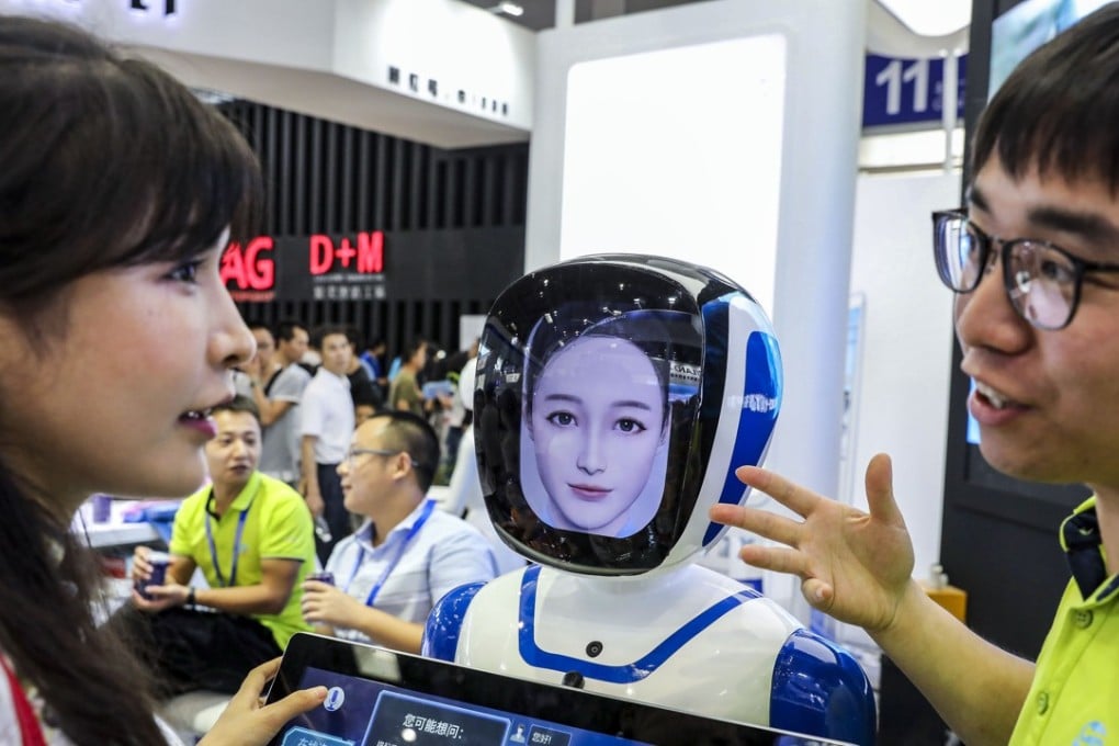 A visitor interacts with a robot, designed by Xi'an Sammer Technology, at the 2018 Smart China Expo held in Chongqing.