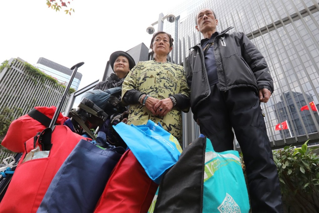 Three homeless residents of Hong Kong protest with the Social Workers Association outside the Hong Kong government offices in Tamar. The stark divide between Hong Kong’s rich and poor has led to increasing calls for action, especially considering ever-rising housing prices and the city’s ongoing budget surpluses. Photo: Edward Wong