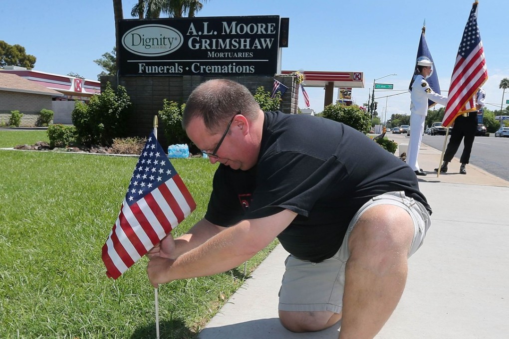 Max Fose of Phoenix, Arizona placing American flags at the Dignity Memorial Mortuary honouring the late Senator. John McCain on Sunday. Photo: AFP