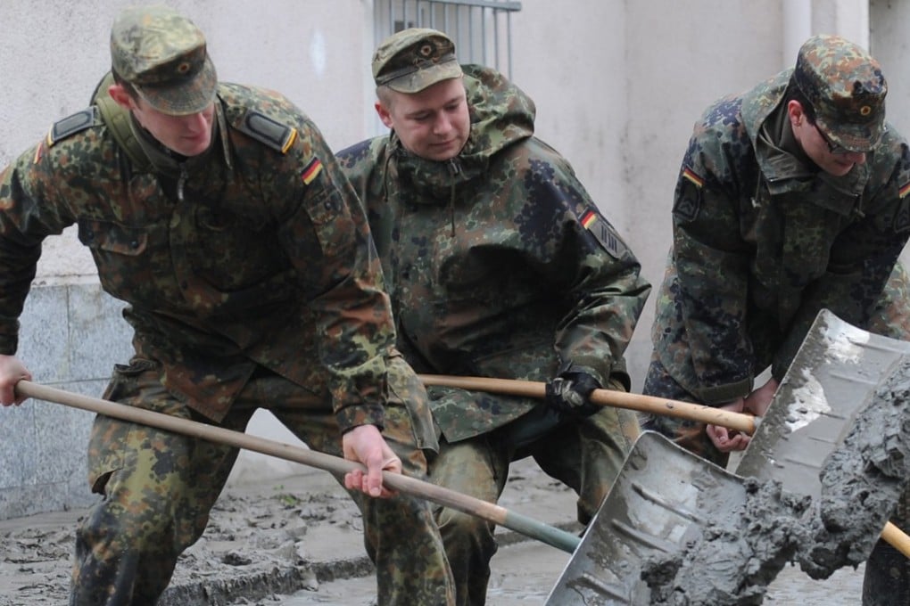 German soldiers shovel mud off a street in Passau, Germany, on June 4, 2013. Photo: AP