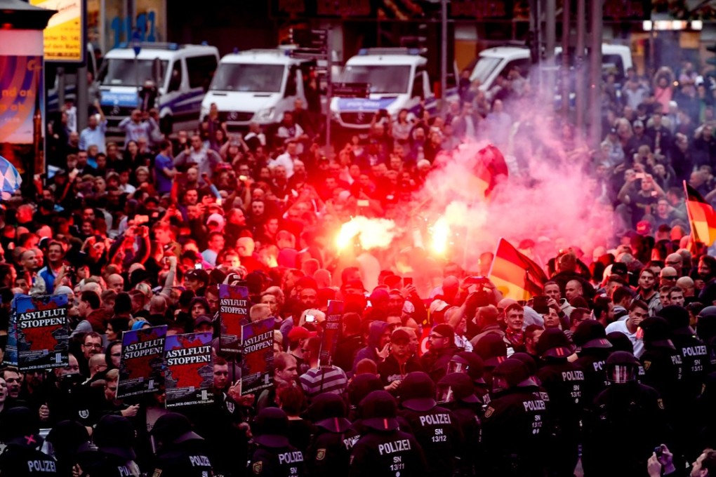 Far-right protesters light flares while facing police as they gather at the place where a man was stabbed on August 25, 2018, in Chemnitz, Germany. Photo: EPA