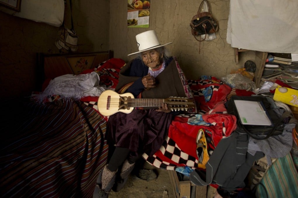 In this August 23, 2018 photo, 117-year-old Julia Flores Colque holds a “charango”, a small Andean guitar, at her home in Sacaba, Bolivia. Photo: AP