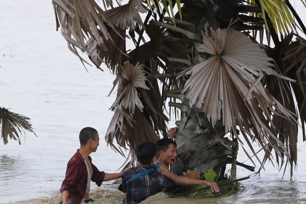 Villagers attempt to traverse a road flooded by waters from the Swar Chaung dam, Bago region, Myanmar on August 29, 2018. Photo: EPA