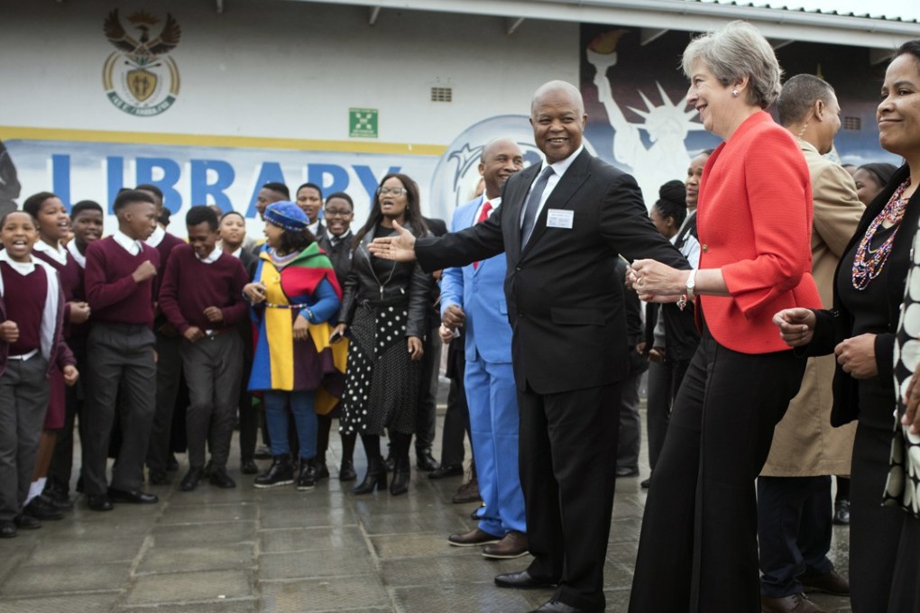 British Prime Minister Theresa May dances with pupils during a visit at the ID Mkhize High School in Gugulethu, Cape Town. Photo: AP