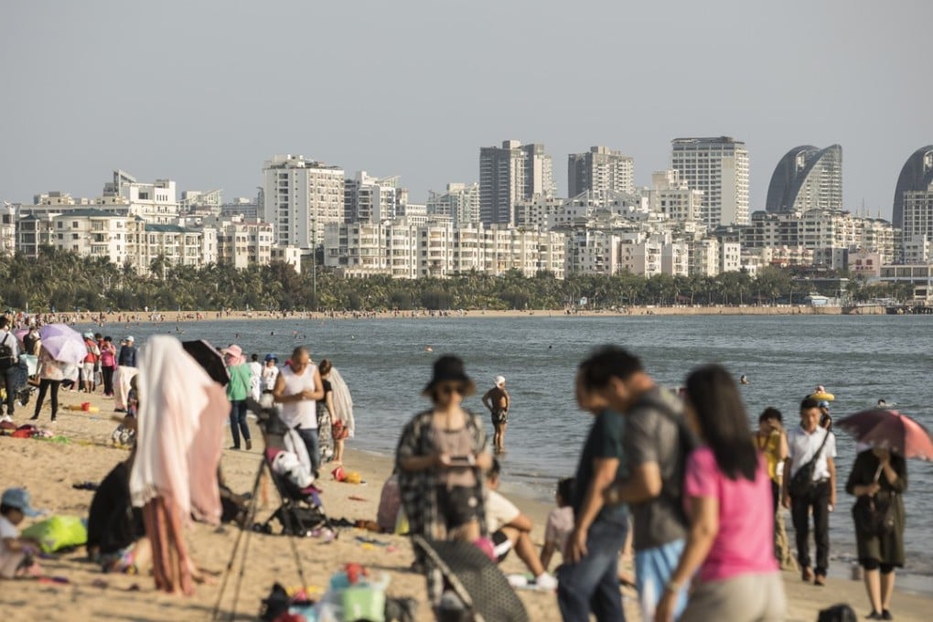 Tourists relax on Sanya Bay beach. Sanya, China’s southern tropical resort city, has introduced the country’s harshest home price cap yet. Photo: Bloomberg