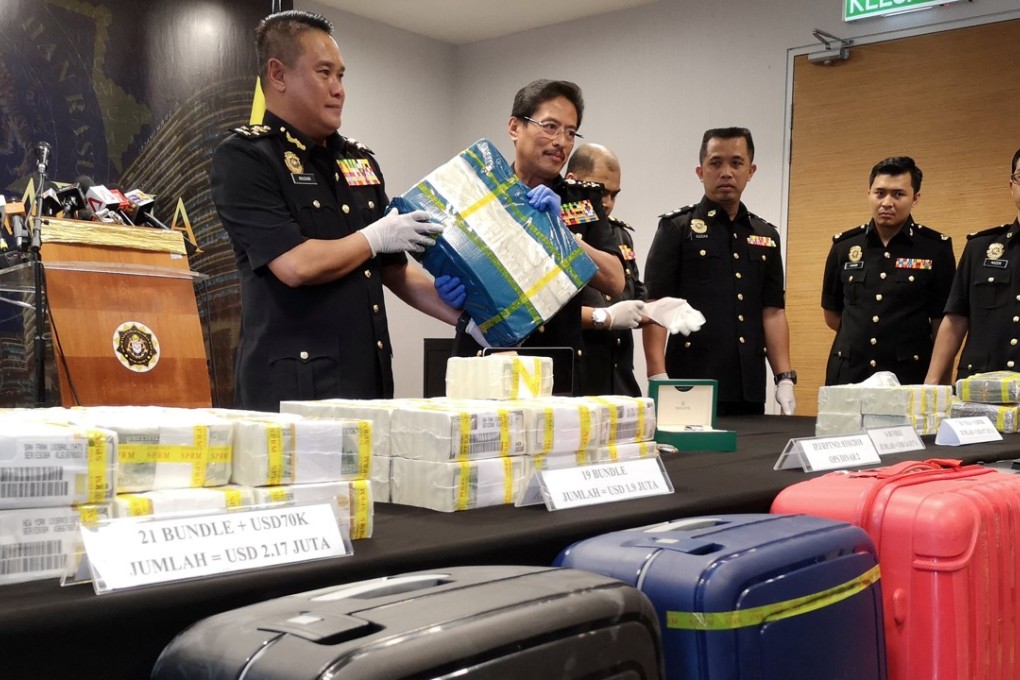Malaysian Anti-Corruption Commission deputy chief commissioner Azmi Baki holds up a bundle of US dollar notes totalling US$1.6 million in Putrajaya, Malaysia, on August 30, 2018. Photo: Reuters
