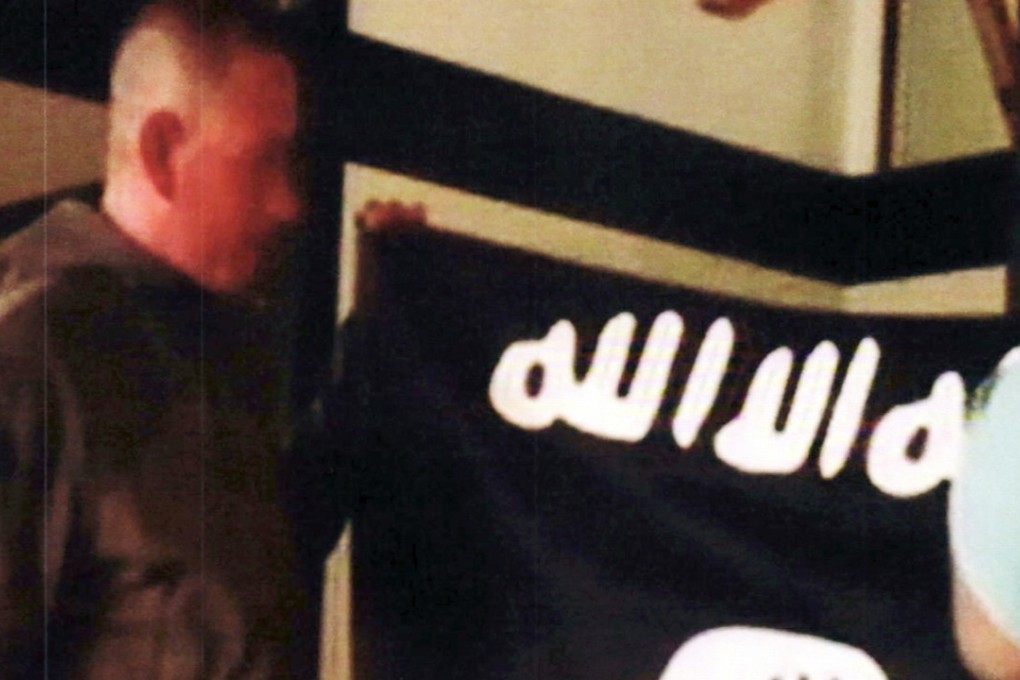 In this July 8, 2017, file image taken from FBI video and provided by the US Attorney's Office in Hawaii, Army Sergeant Ikaika Kang holds an Islamic State group flag after allegedly pledging allegiance to the terror group at a house in Honolulu. Photo: AP