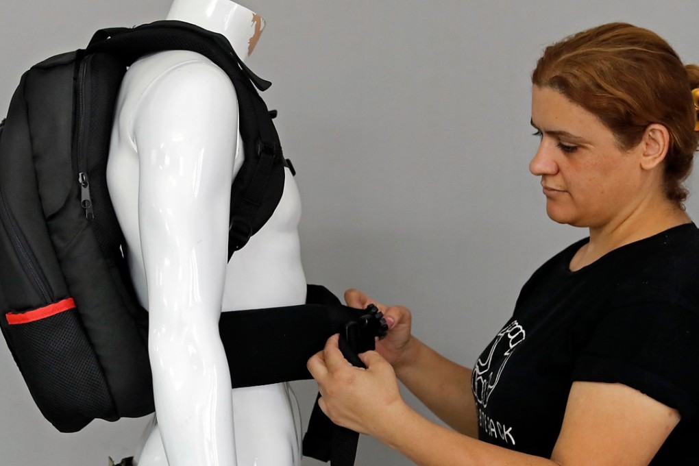 An employee of the Israeli protection gear manufacturer Masada Armour adjusts a new civilian bulletproof backpack, designed for schoolchildren, at the company's headquarters in Julis, Israel, on Thursday. Photo: Agence France-Presse