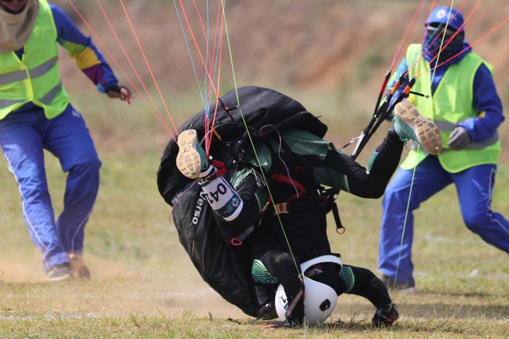 Ariunbat Khadkhuu (centre) of Mongolia endures a hard landing during the paragliding men’s individual accuracy competition at the 18th Asian Games. Photo: EPA