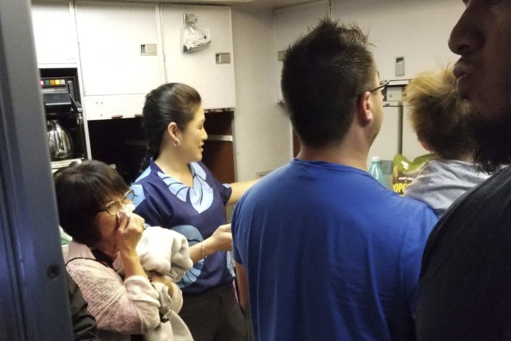 People gathered at the back of the Hawaiian Airlines flight after a can of pepper spray went off. Photo: AP/Nicholas Andrade