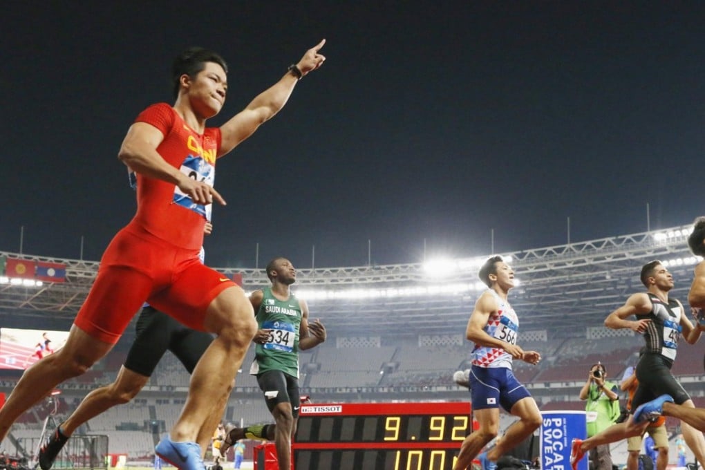 Su Bingtian raises his hand in triumph after winning the 100 metres. Photo: Kyodo