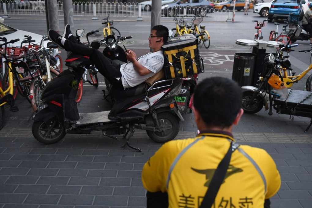 Meituan delivery riders wait for food delivery assignments in Beijing on June 26, 2018. Photo: AFP