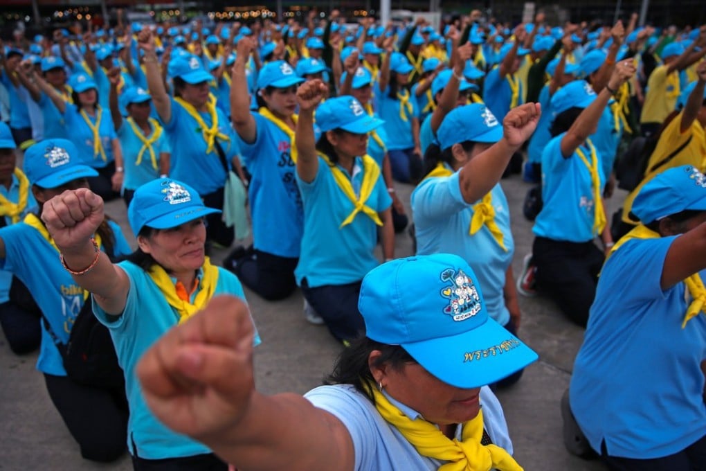 King’s volunteers shout slogans before the start of a cleaning programme in Bangkok. Photo: Reuters