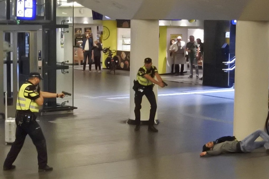 Dutch police officers pointing their guns at a wounded 19-year-old man who was shot by police after stabbing two people in the central railway station in Amsterdam, the Netherlands, on Friday. The suspect in the case said on Monday he was motivated by insults to Islam, according to prosecutors. Photo: AP