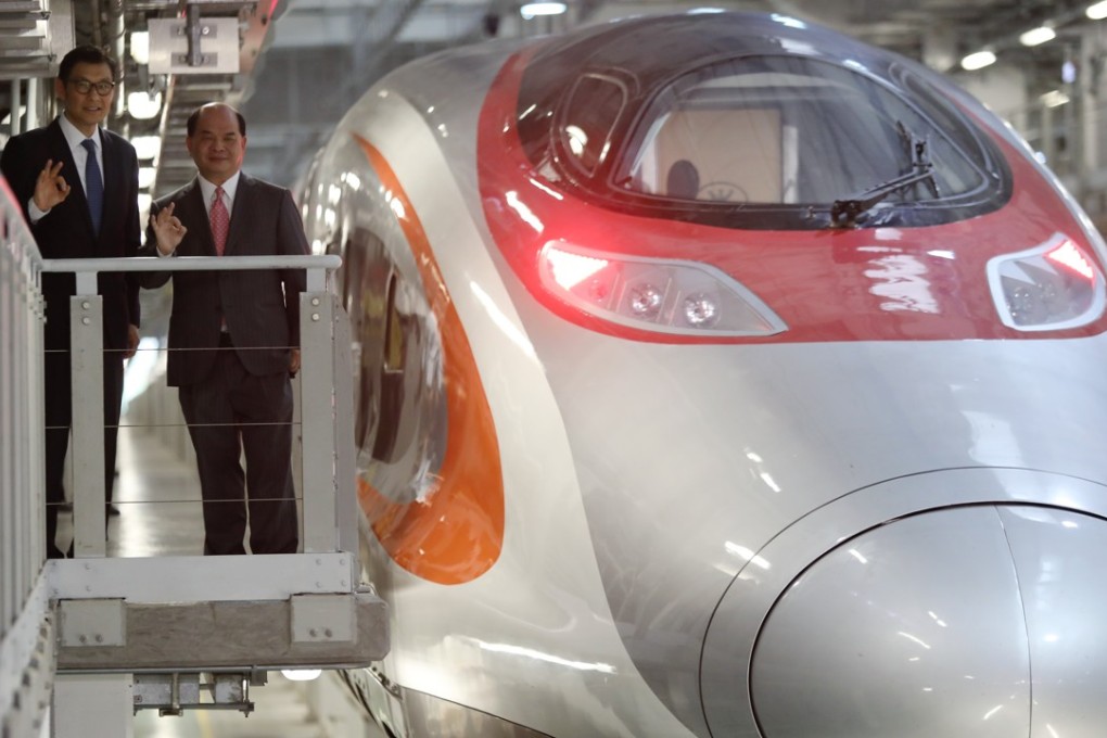 Simon Tang Wai-yung (left), general manager, and Francis Li Shing-kee, chief of operations, of the high-speed rail pose for a photo next to a train at the West Kowloon terminus on August 16. Photo: Sam Tsang