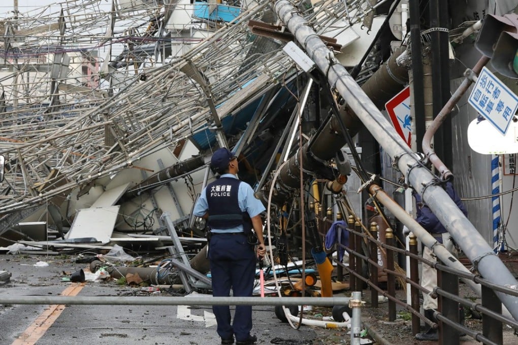 Traffic boards and telecommunication relay poles were brought down by Typhoon Jebi in Osaka. Photo: AFP