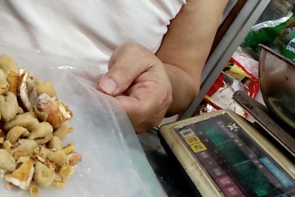 A man in a shop in Hong Kong offers processed pangolin scales from Guangxi province for sale. Photo: SCMP