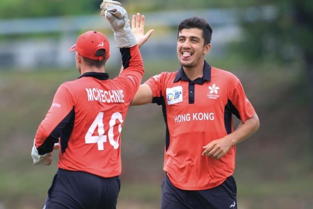 Scott McKechnie and Aizaz Khan celebrate one of the latter's five wickets. Photo: ACC