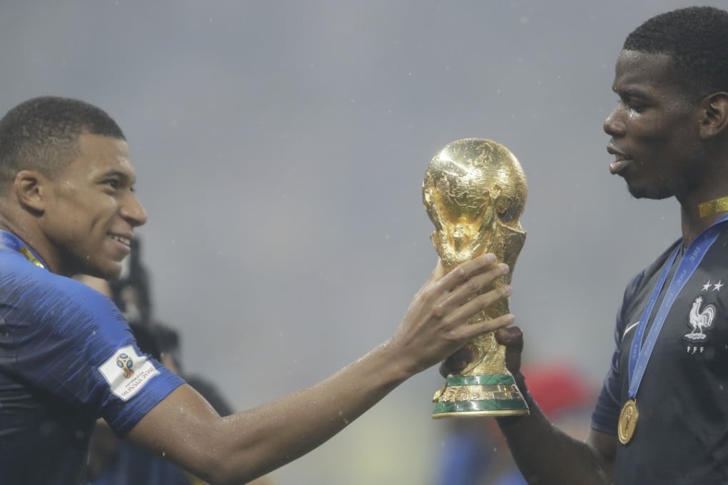 France’s Kylian Mbappe hands the World Cup trophy to Paul Pogba after the 2018 final. Photo: AP