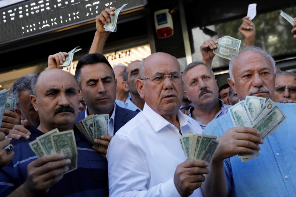 Businessmen holding US dollars stand in front of a currency exchange office in Ankara on August 14 in response to Turkish President Recep Tayyip Erdogan’s call to Turks to sell their dollar and euro savings to support the lira. Photo: Reuters