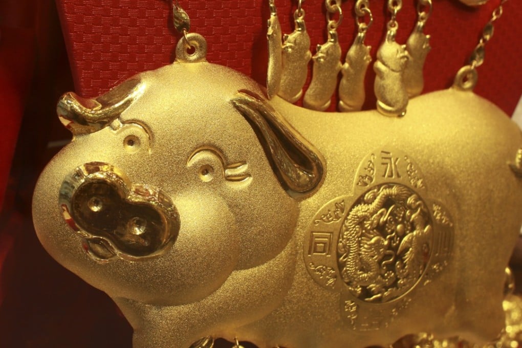 Gold pigs sit inside a display case at a Wo Shing Goldsmith store on Shanghai Street, Yau Ma Tei on March 2, 2017. Photo: May Tse