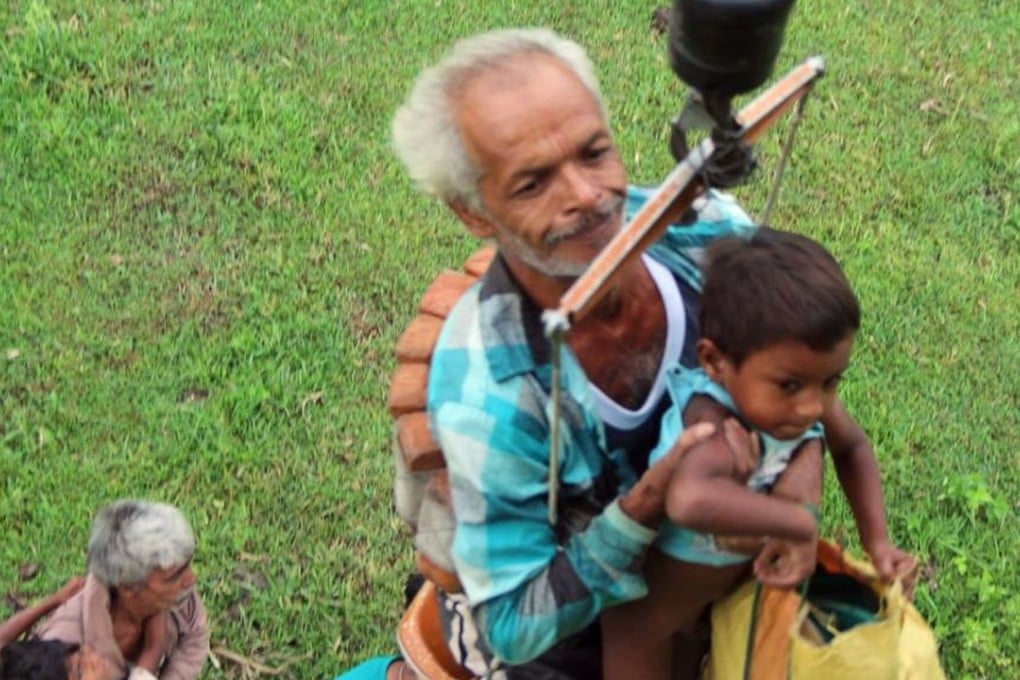 A man and child are airlifted from an isolated island in the Siang river. Photo: Handout