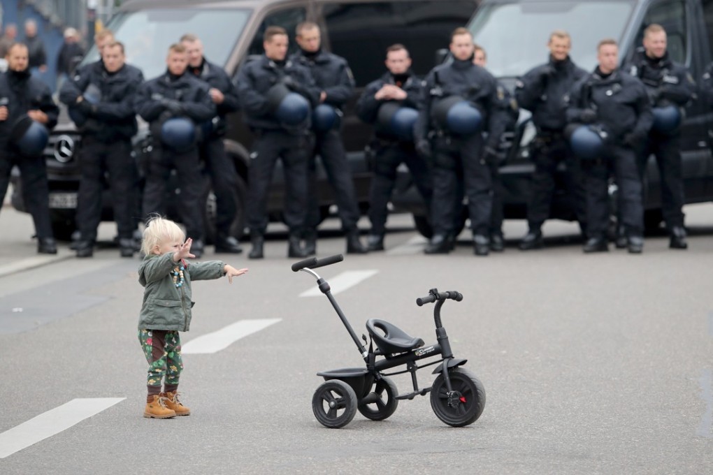 A child plays in front of police officers near a demonstration by a right-wing group in Chemnitz, Germany, on September 1. Organisations of civil society and right-wing groups called for several demonstrations that weekend after two refugees from Syria and Iraq were arrested on suspicion of stabbing a 35-year-old man to death. Photo: EPA