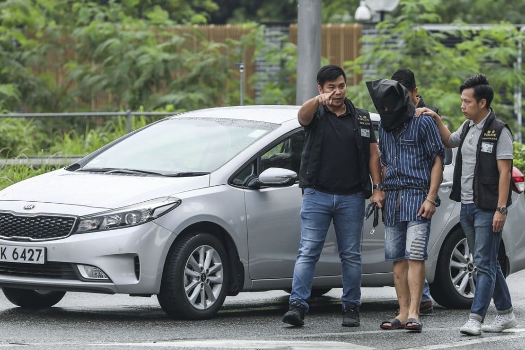 Police officers bring the suspect to the spot where the sergeant fired one round. Photo: Roy Issa
