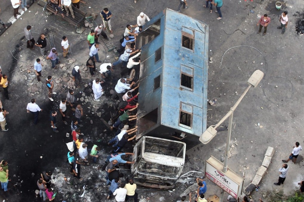 Supporters of ousted Egyptian president Mursi push over a truck during protests in Giza on August 14, 2013. Photo: EPA