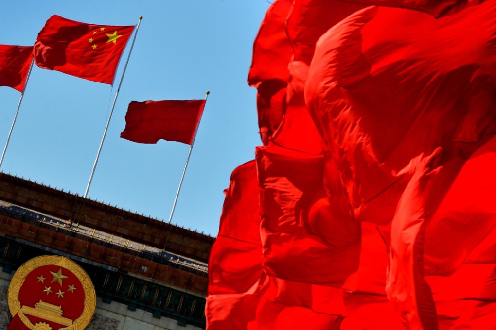 Chinese flags fly over the Great Hall of the People, the site of the Communist Party Congress, in Beijing. One problem for China’s party is that state-owned enterprises play a vital role in sustaining one-party rule, but the bloated and inefficient firms suck scarce resources out of the economy. Photo: AFP