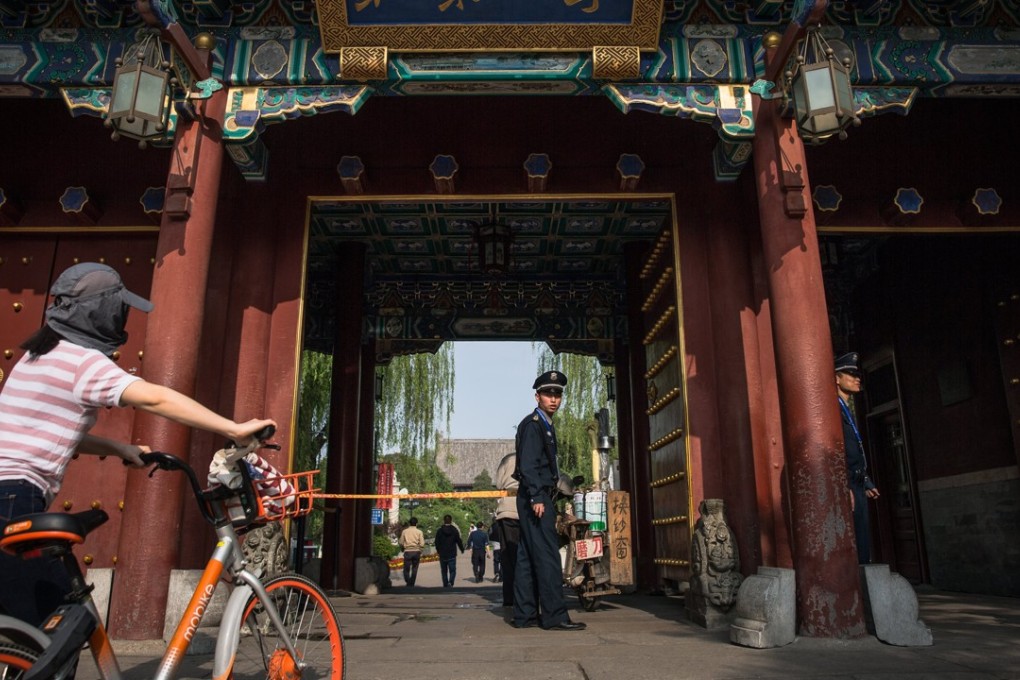 A security guard keeps watch at the entrance of Peking University in Beijing. Photo: EPA