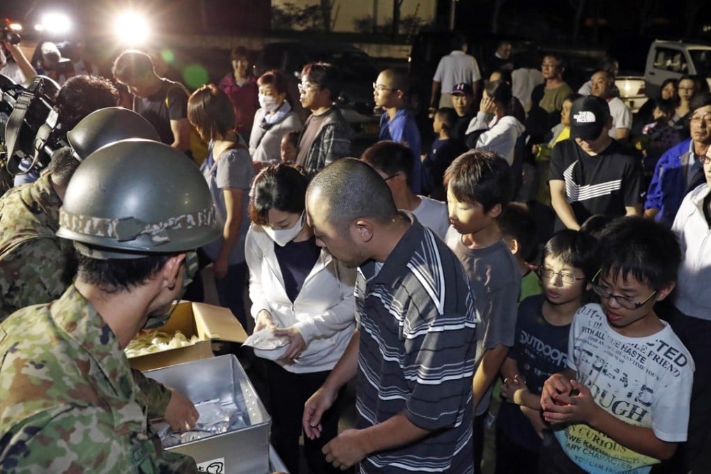 People wait for food at a shelter in Atsuma, Japan. Photo: Kyodo