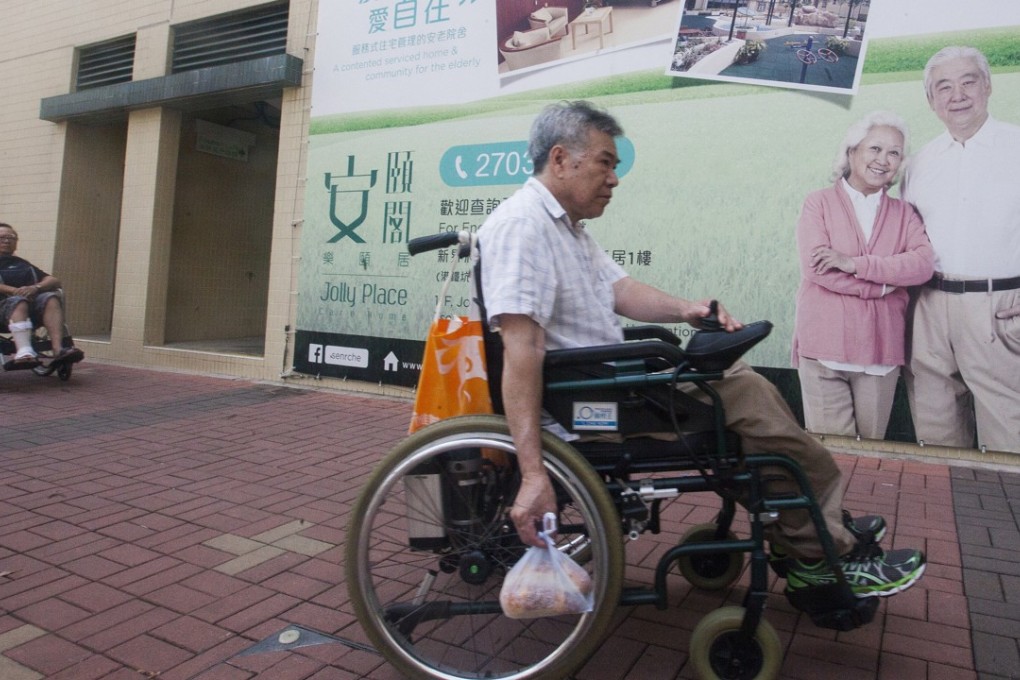 An elderly person passes a billboard advert for a care home near a public housing estate in Tseung Kwan O, on July 6. Hong Kong is facing a “silver tsunami” as the population ages. Photo: EPA-EFE