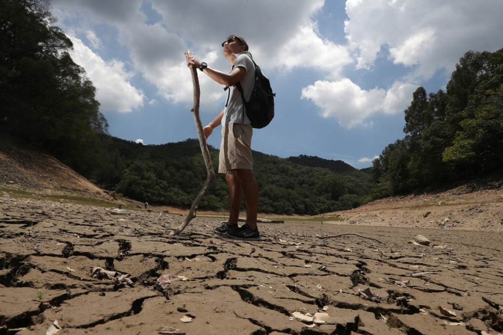 A hiker walks across the dried-up bed of the Lau Shui Heung Reservoir in Fanling, during a record-breaking heatwave in Hong Kong in May. Photo: K.Y. Cheng