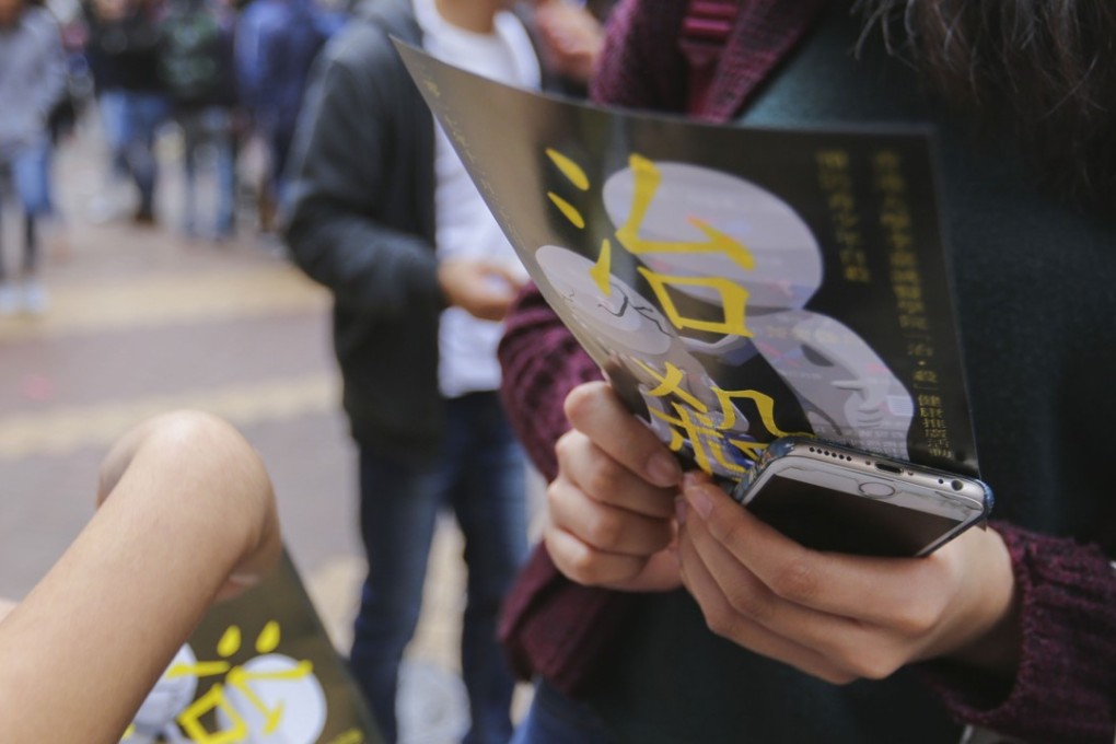 A student holds a pamphlet as part of a “Let’s Talk about Suicide” campaign about youth suicide prevention, by University of Hong Kong medical students in Causeway Bay in November 2017. Photo: Xiaomei Chen