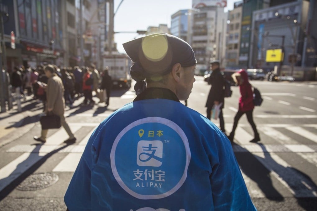 A staff member wearing a uniform featuring the logo for Ant Financial Services Group's Alipay, at a campaign event in Tokyo on December 9. Photo: Bloomberg