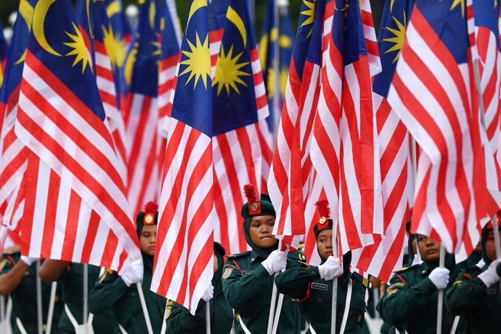 Malaysian school cadets carry national flags during the National Day celebration parade in Putrajaya, on the outskirts of Kuala Lumpur, on August 31. Malaysia celebrates its independence from British rule on that day, and the formation of the Federation of Malaysia on September 16. Photo: AFP