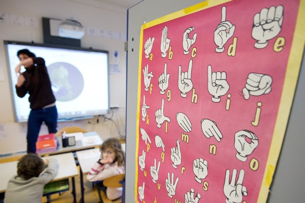 A teacher uses sign language to communicate with hearing-impaired pupils at a school in France. Picture: AFP