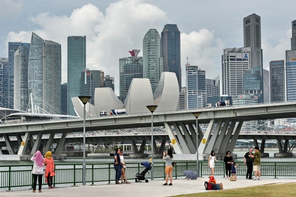 People enjoy the view of the city skyline along Marina Bay in Singapore. Photo: AFP