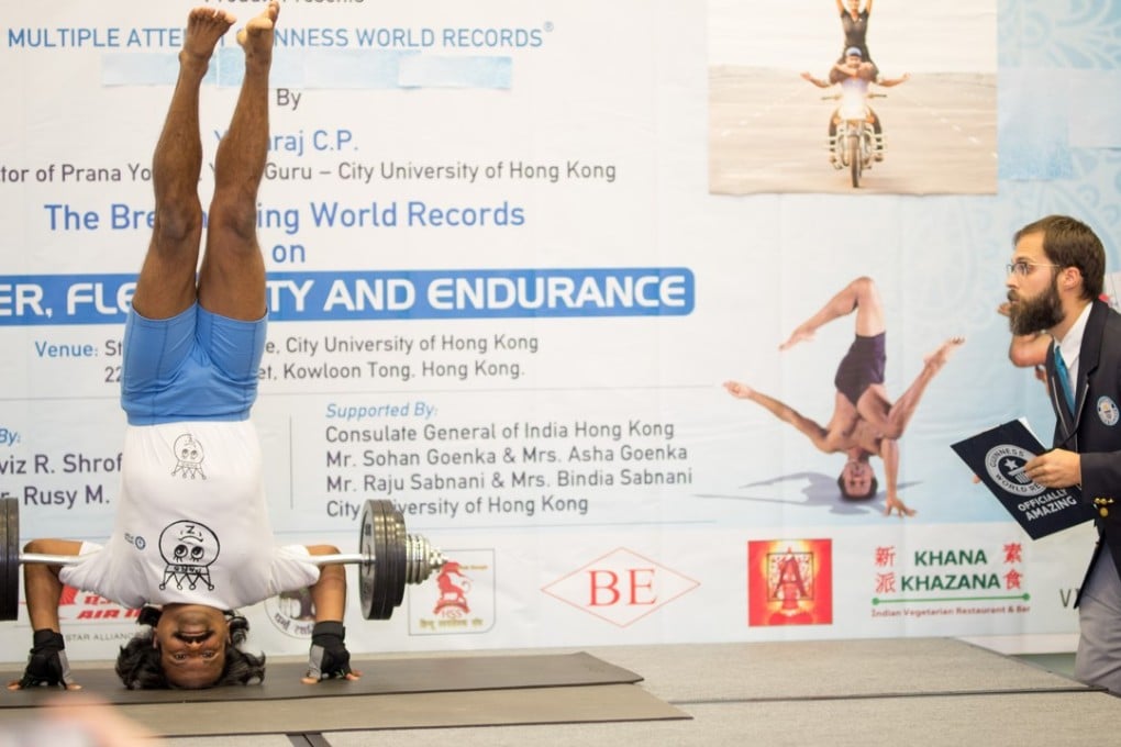 Yogaraj performs his record-breaking headstand in Hong Kong with Guinness adjudicator looking on. Photo: Davinder Chohan