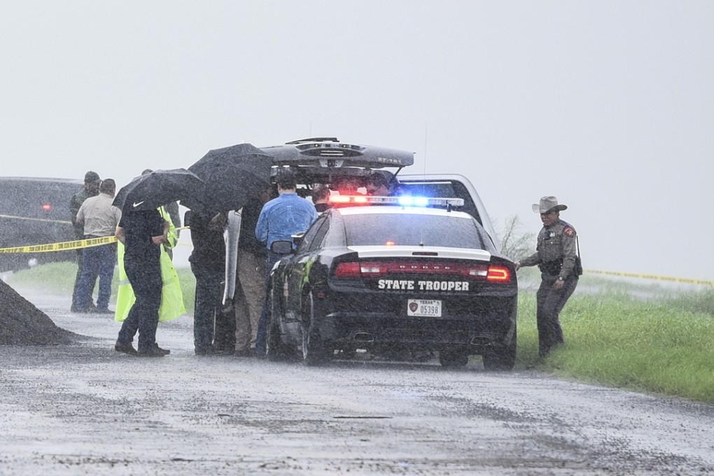 Law enforcement officers gather near the scene where the body of a woman was found north of Laredo, Texas on Saturday. Photo: AP