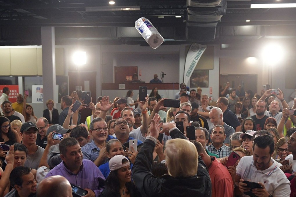 US President Donald Trump throws a paper towel roll as he visits the Cavalry Chapel in Guaynabo, Puerto Rico in 2017. File photo: AFP